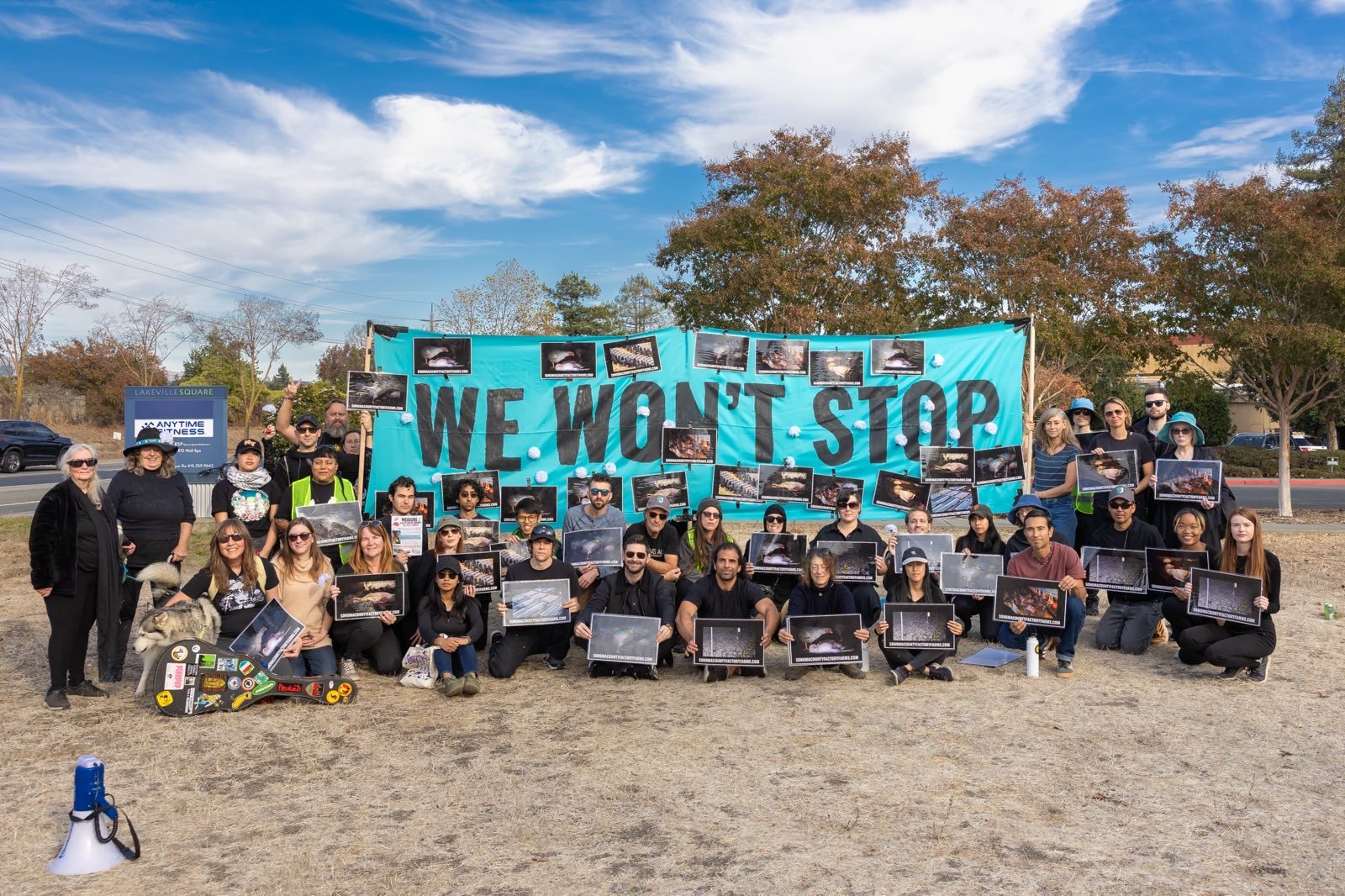 Coalition to End Factory Farming volunteers holding a “We Won’t Stop” banner